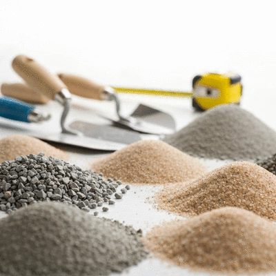 Close-up of various concrete mixes and aggregates, with construction tools in the background, clean image